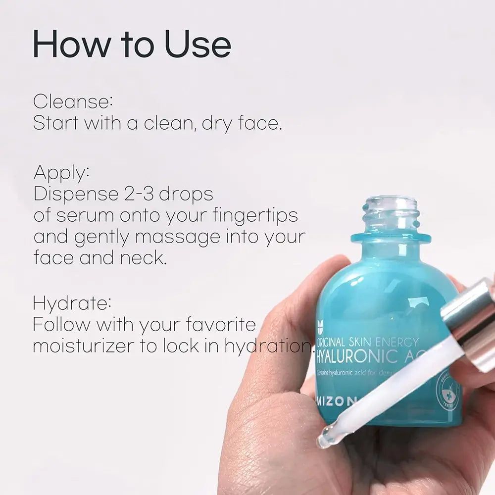 Main tenant flacon avec pipette. Inscription : Original Skin Energy Hyaluronic Acid 100. Instructions : Nettoyer, appliquer, hydrater. Marque Mizon.