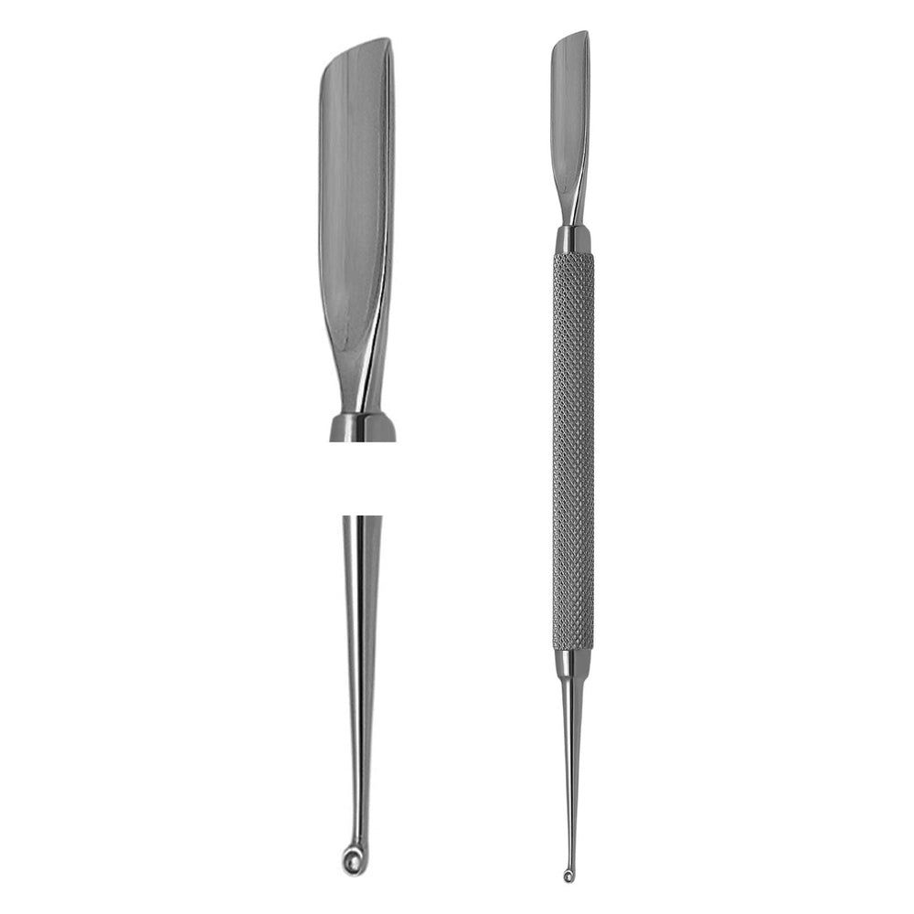 Pousse-cuticules et extracteur de comédons en métal. Une extrémité en forme de spatule, l'autre pointue avec une petite ouverture. Manche moleté. Gros plan.