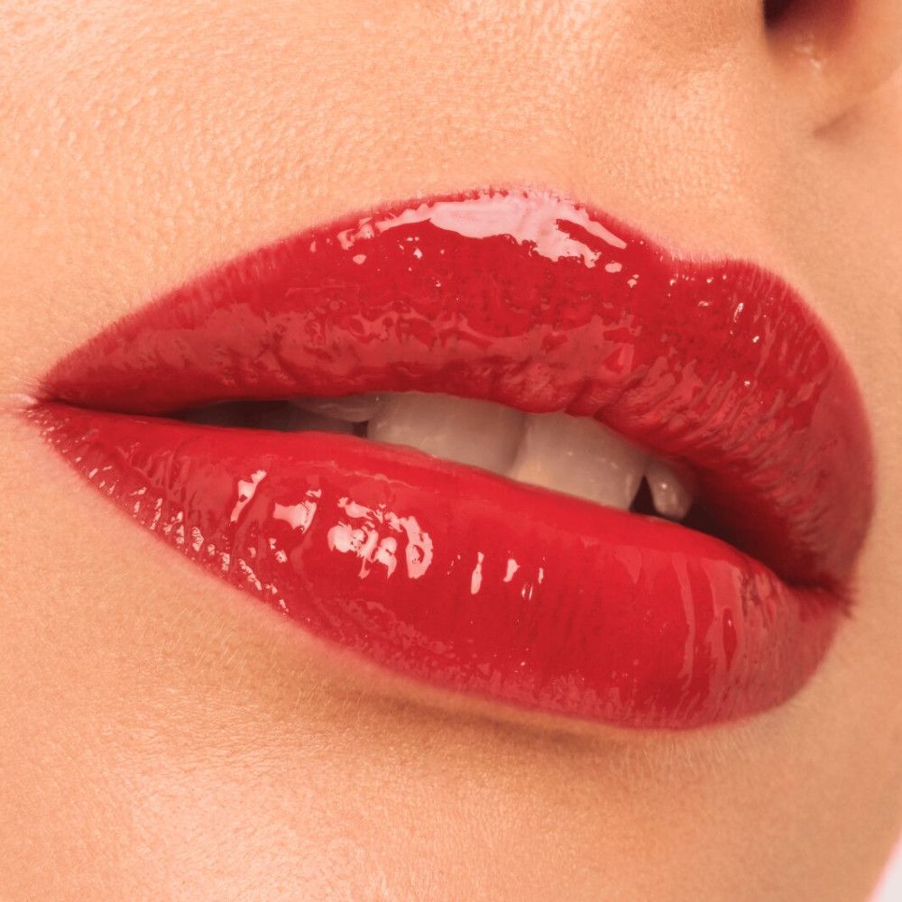 Close-up van rode, glanzende lippen. De lippen zijn open en tonen tanden.