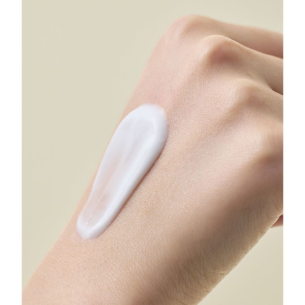 Main avec crème sur la peau. Crème blanche, texture lisse.