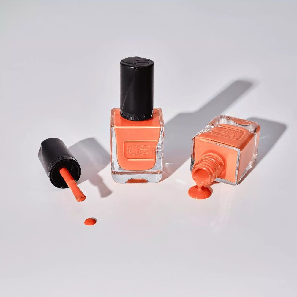 Flacons de vernis à ongles, un renversé. Couleur : orange. Marque Catrice.