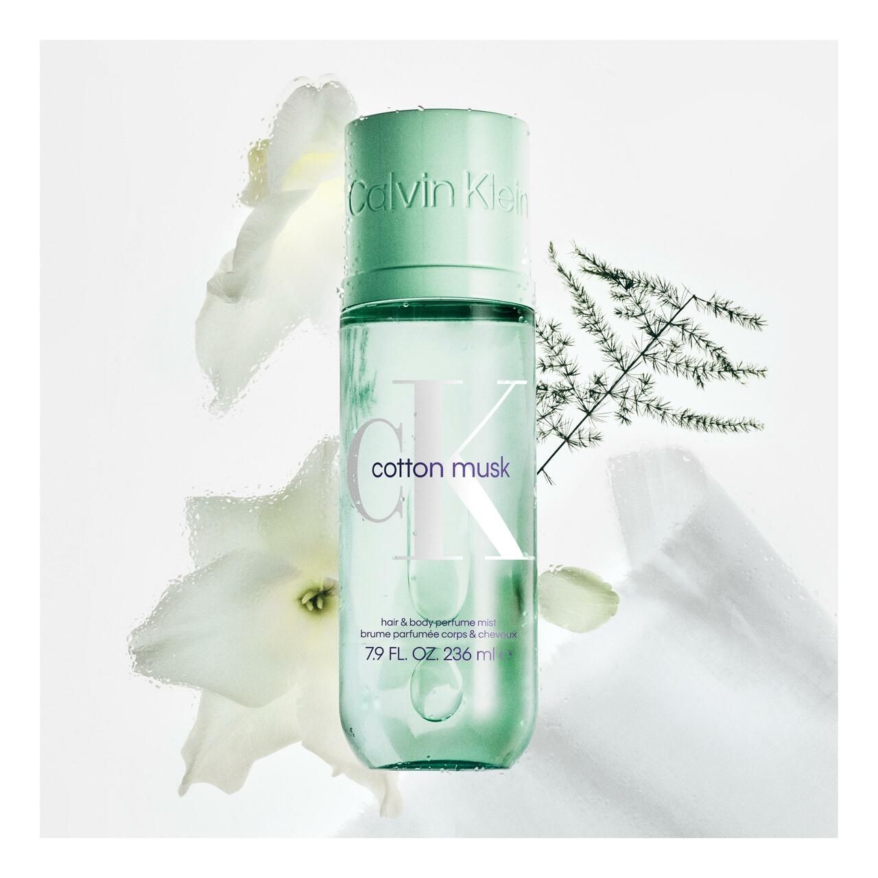 Groene fles met verstuiver. Opschrift Calvin Klein, cotton musk. 79 FL. OZ. 236 ml. Decoratie met bloemen en takken.