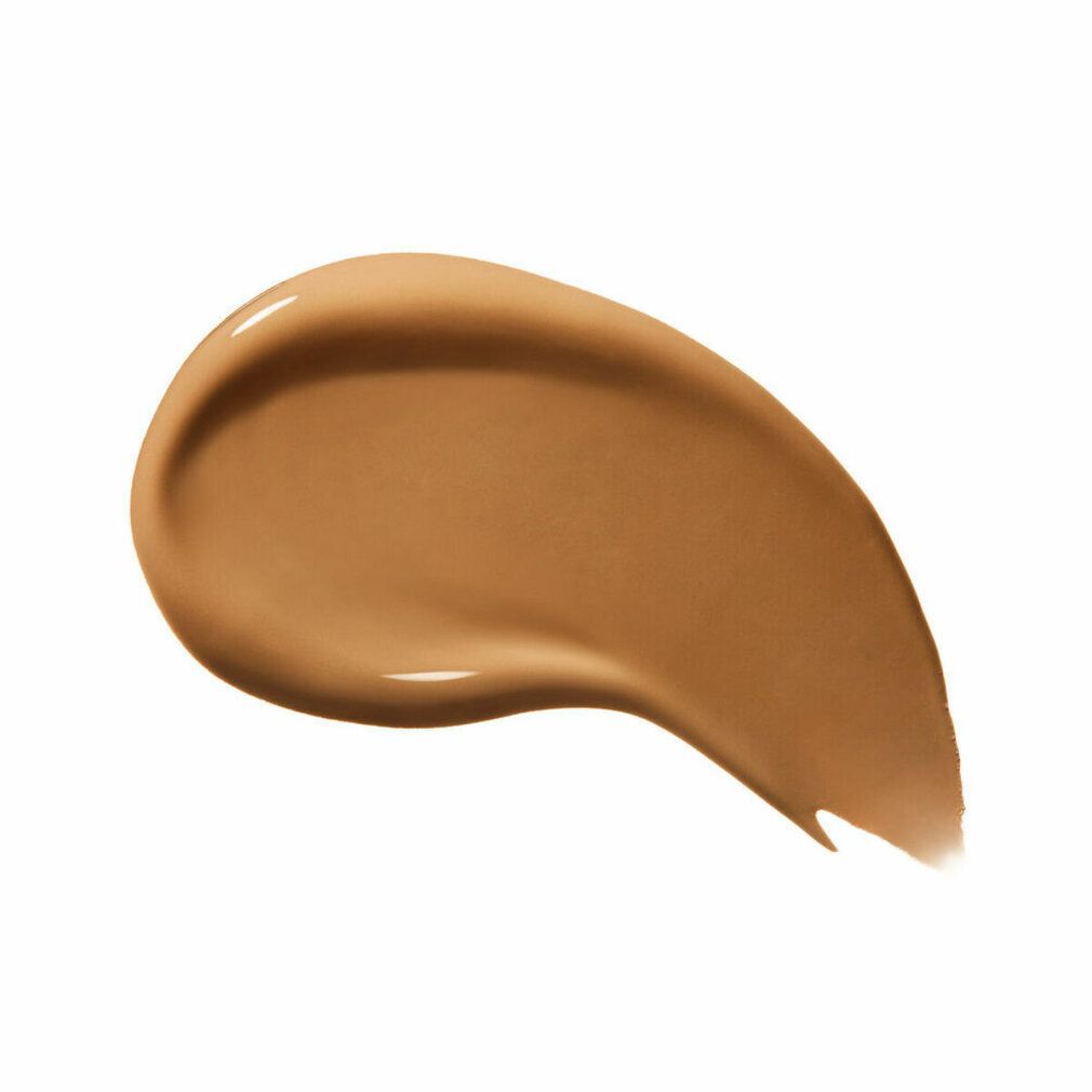 Échantillon de fond de teint. Application en forme de goutte de couleur bronze. Surface brillante. Sur fond blanc.