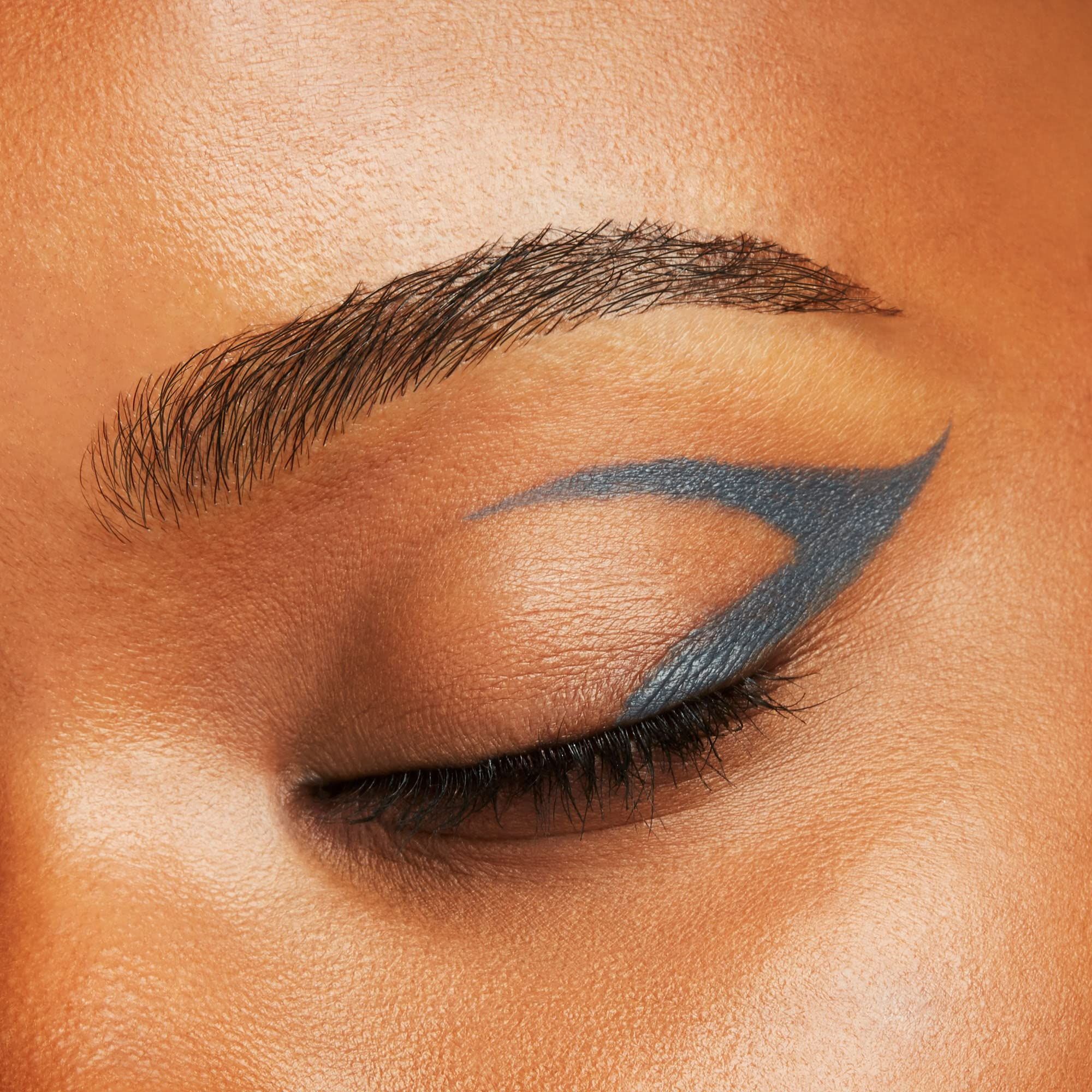 Œil avec un trait d'eye-liner gris. Le trait de liner longe la paupière supérieure et forme une aile.