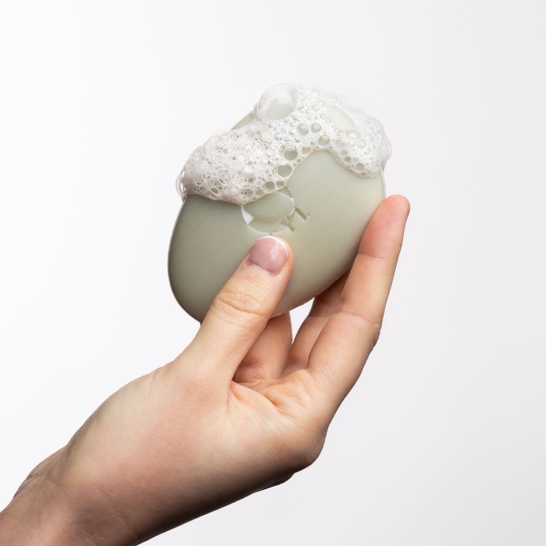 Ovale zeep in hand, bedekt met schuim.