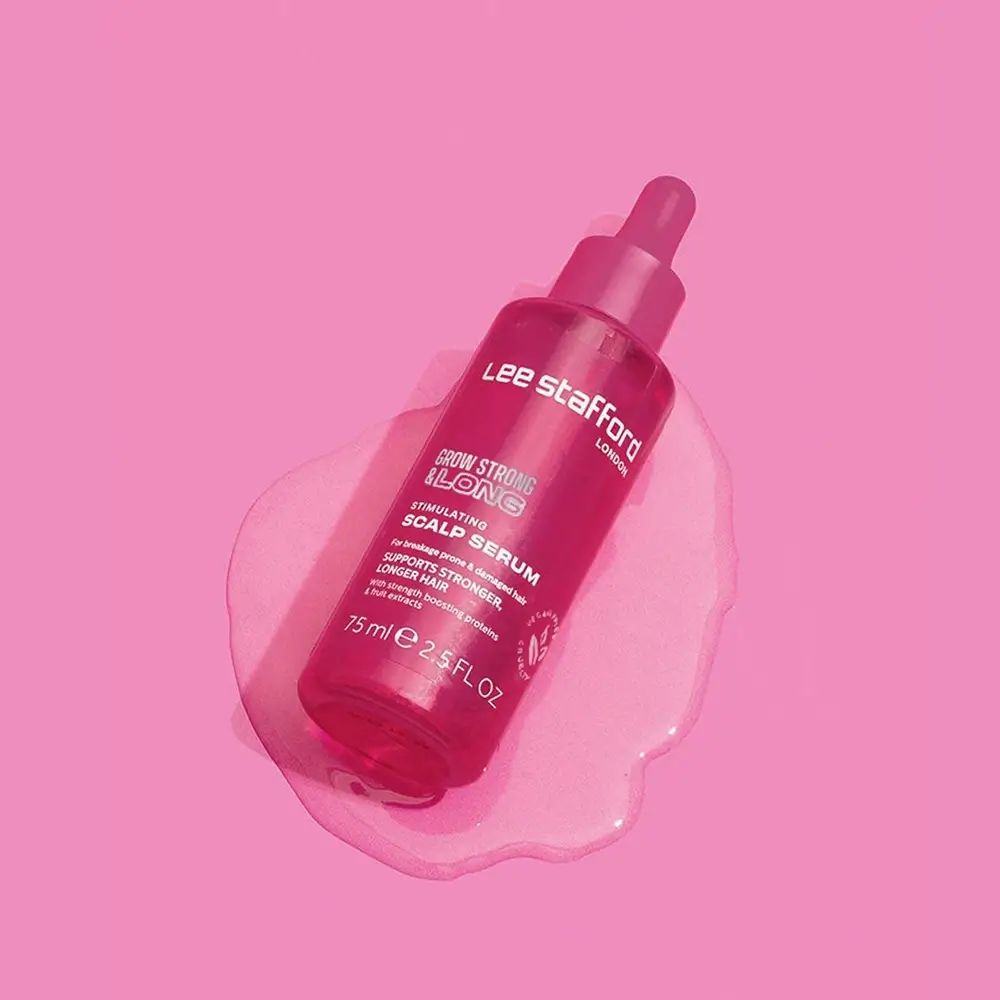 Flacon rose à pipette du sérum stimulant pour cuir chevelu Grow Strong & Long de Lee Stafford sur fond rose.