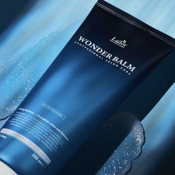 LADOR Wonder Balm tube, blauw, met waterdruppels. Professionele haarverzorging voor glans en zachtheid.