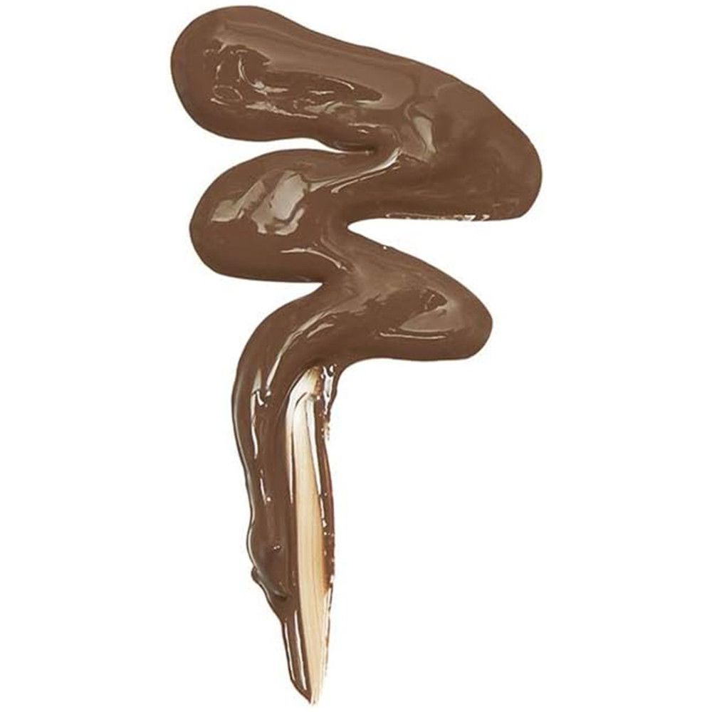 Nuance de correcteur brun en forme de vague sur fond clair. Texture visible.