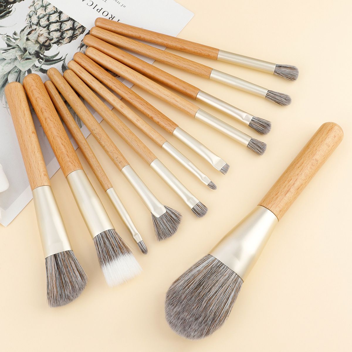 Ensemble de 11 pinceaux de maquillage avec manches en bois et viroles argentées.