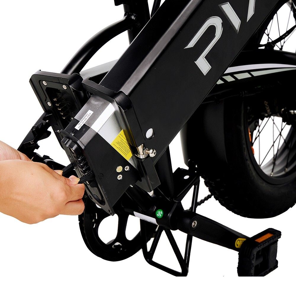 Close-up van de elektrische fiets. Hand verbindt kabel met accu. Pedalen en frame zichtbaar.