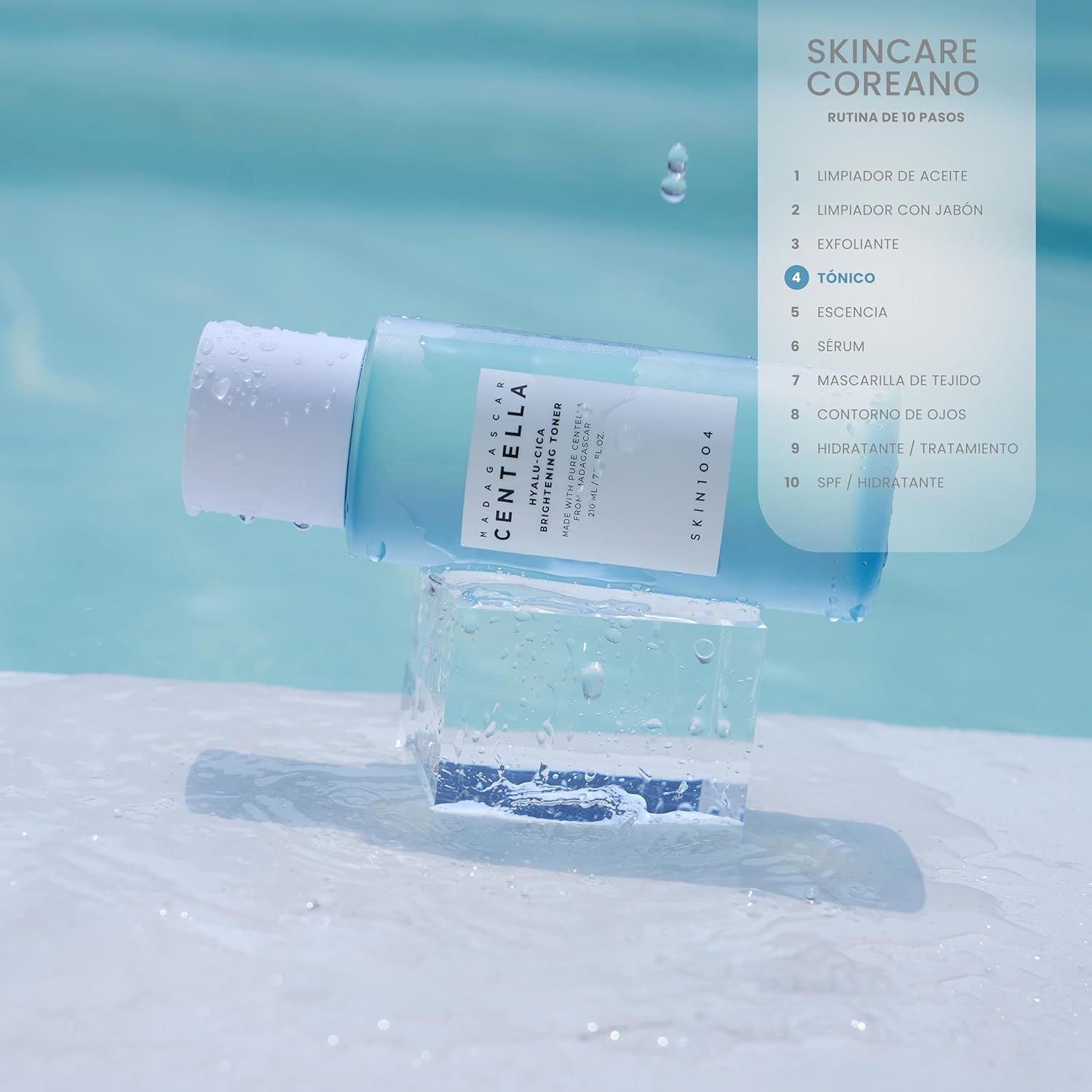 Lichtblauwe fles op ijsblokjes. Opschrift: MADAGASCAR CENTELLA HYALU-CICA BRIGHTENING TONER. Koreaanse huidverzorgingsroutine.