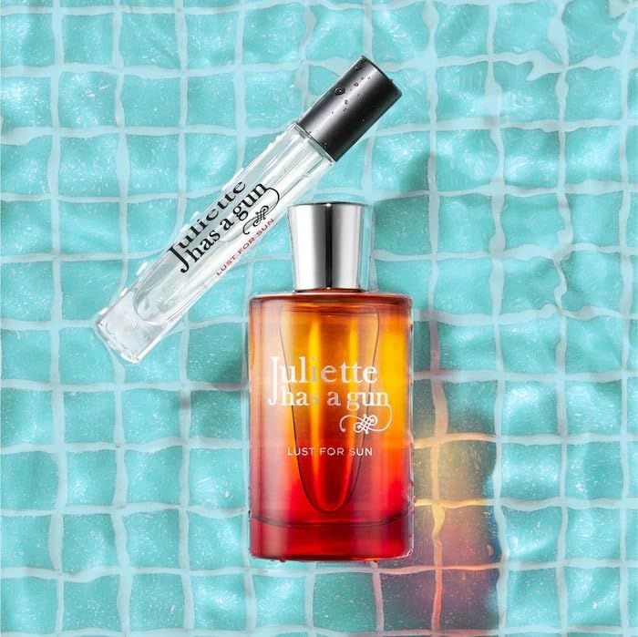 Parfumfles en kleine fles op blauwe achtergrond. Flessen met rood-gele kleurovergang.