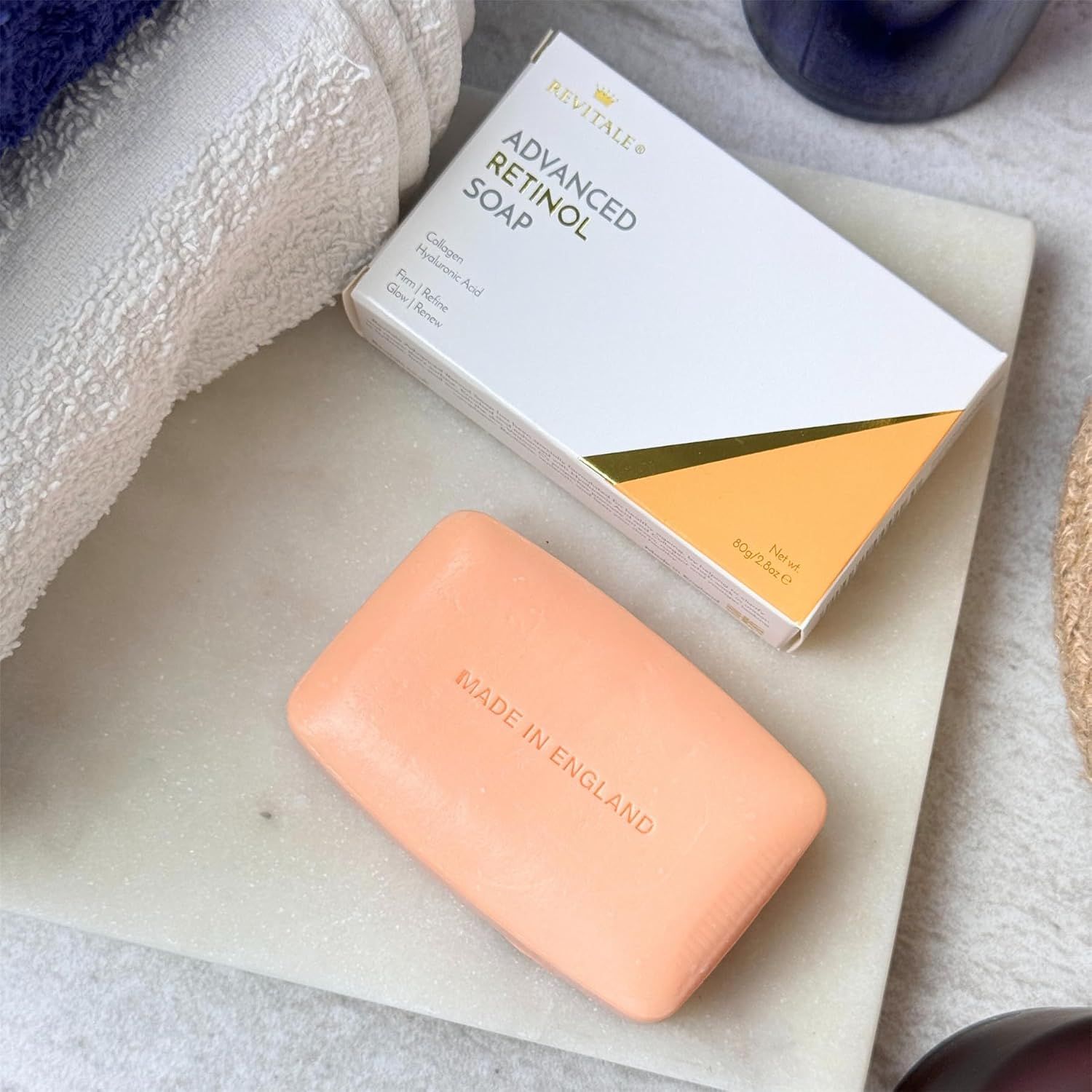 Un pain de savon orange clair avec "MADE IN ENGLAND" gravé, à côté d'une boîte "ADVANCED RETINOL SOAP".