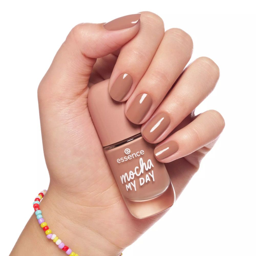 Main tenant un flacon de vernis à ongles. Ongles vernis. Inscription "essence mocha MY DAY".