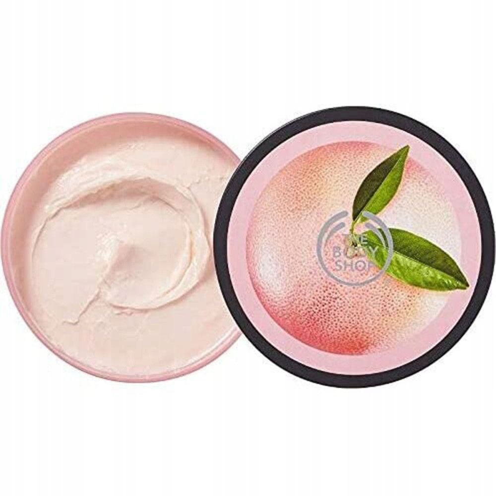 Geopende pot body butter. Roze crème, ernaast deksel met grapefruitmotief en logo.