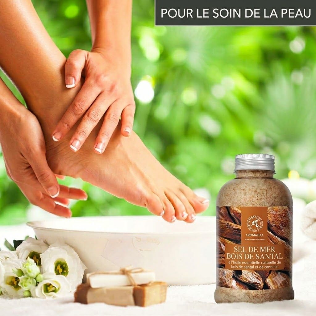 Bouteille de sel de mer au bois de santal près d'un pied dans une bassine. Trois savons sont posés devant.