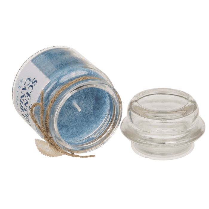 Bougie parfumée en verre, couvercle à côté. Cire bleue, étiquette avec ancre et texte "SCENTED CANDLE Ocean". Décorée d'un coquillage.