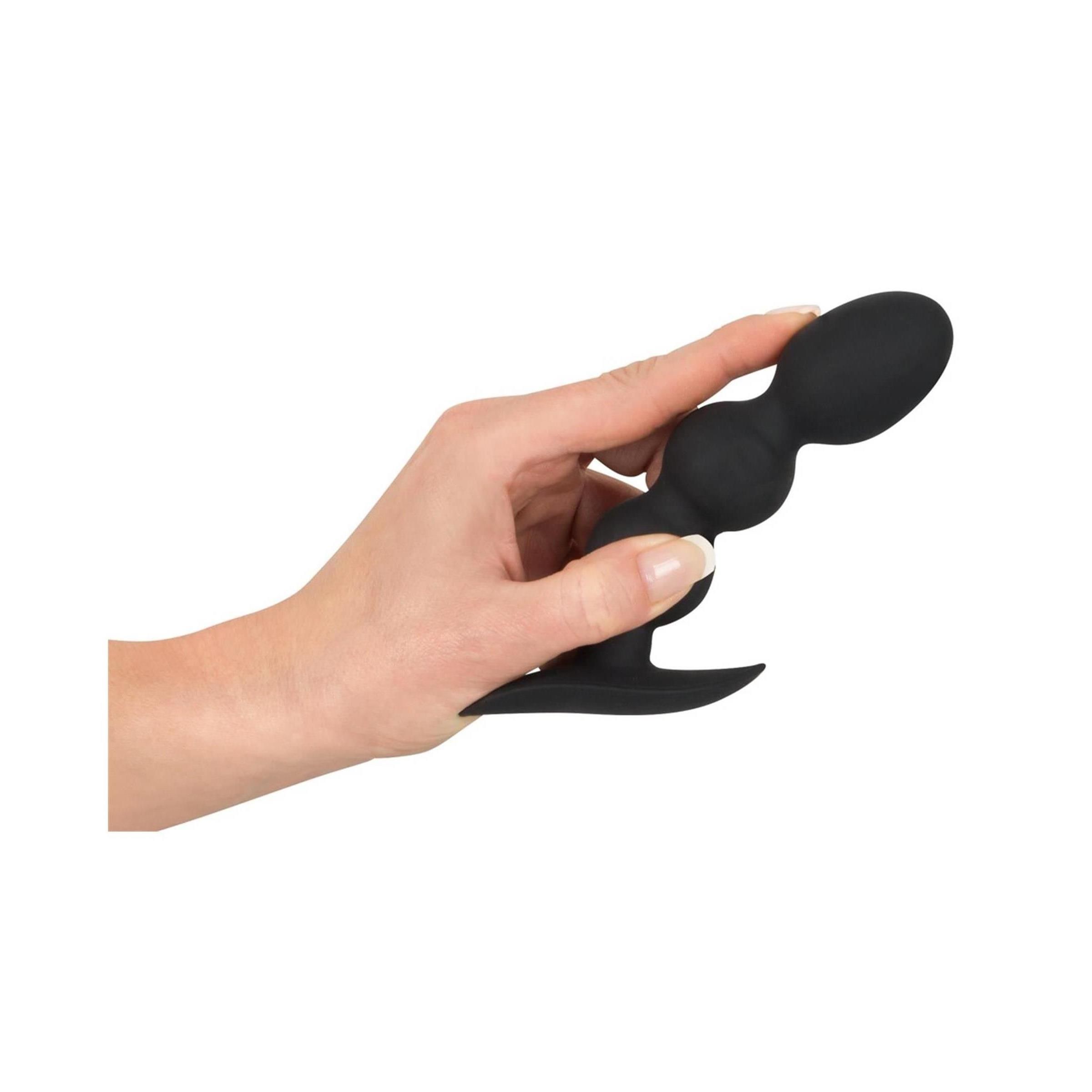 Zwarte anale plug met drie bollen en brede flens, close-up.