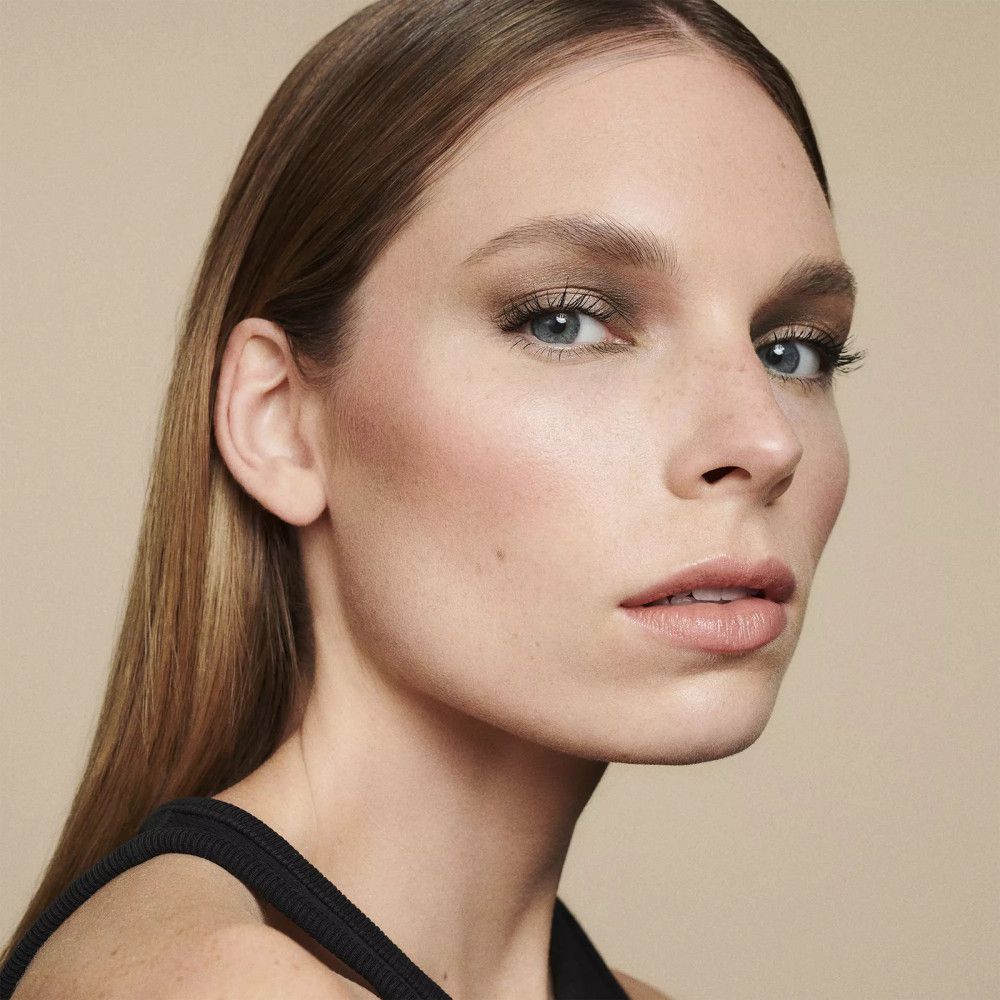 Portrait d'une femme maquillée. Fard à joues sur les joues. Peau claire, yeux bleus, cheveux blonds.