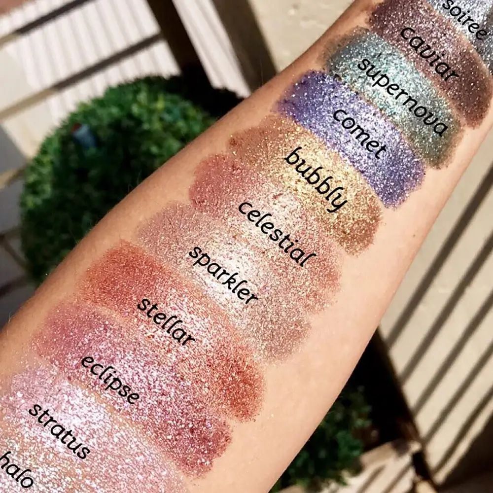 Arm met verschillende oogschaduwswatches. Namen als 'Celestial' en 'Sparkler' zijn zichtbaar.