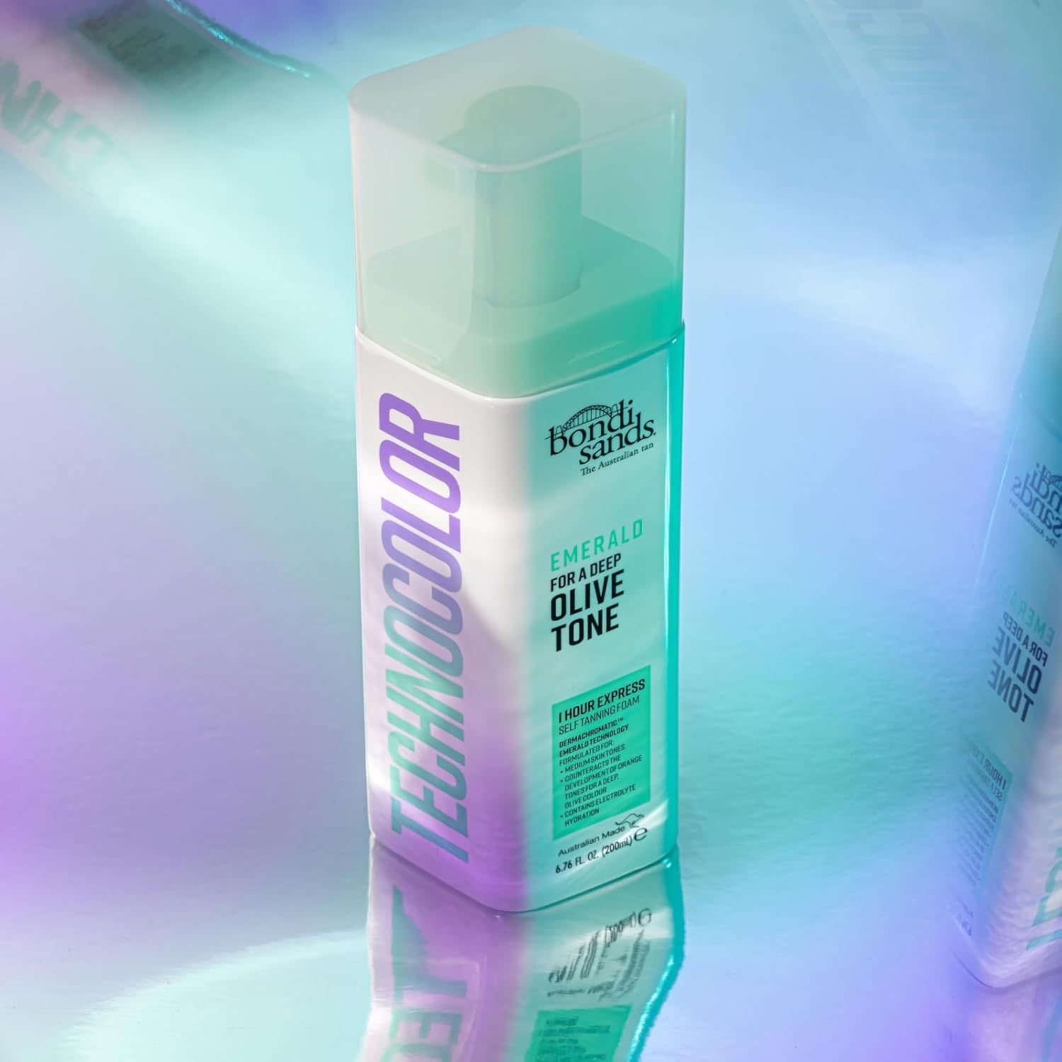 Mousse autobronzante Bondi Sands. Flacon vert et blanc. Texte : Emerald pour un ton olive profond. Technocolor.