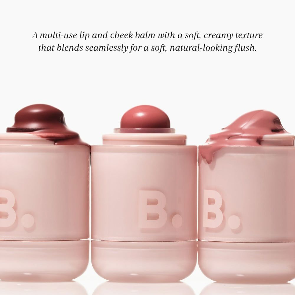 Trois baumes pour les lèvres et les joues roses. Les couvercles sont recouverts de produit. Le logo "B." est visible sur les pots.