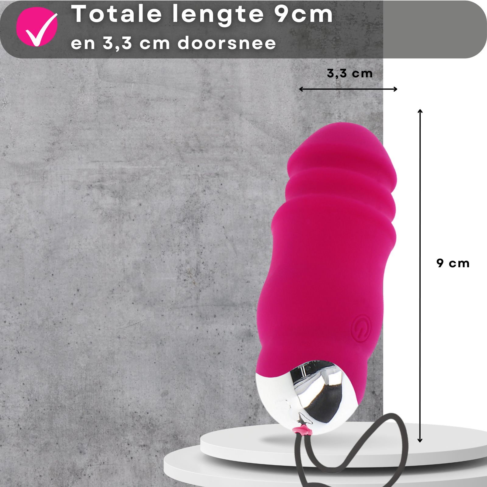 Roze vibratie-ei. 9cm lang, 3,3cm diameter. Op voetstuk. Afmetingen getoond. Grijze achtergrond.