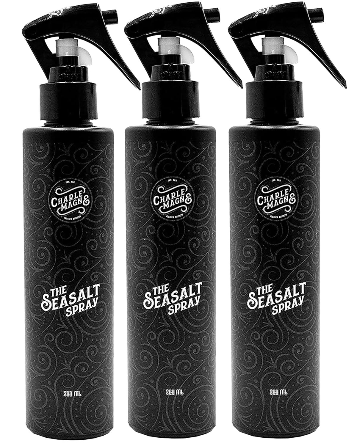 Trois flacons pulvérisateurs noirs avec le logo "Charle Magne" et l'inscription "The Seasalt Spray".