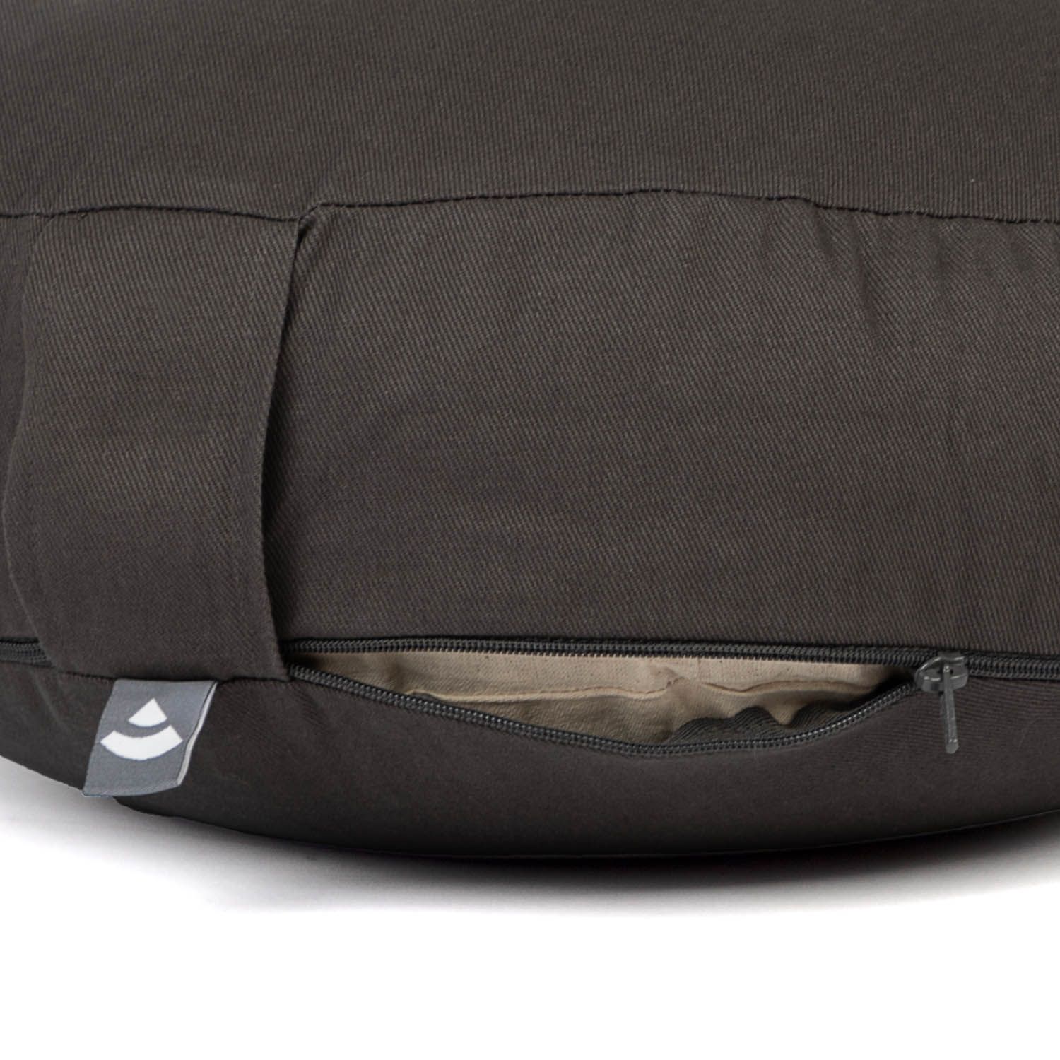 Rond bruin meditatiekussen met rits en handvat. Logo-label aan de zijkant.