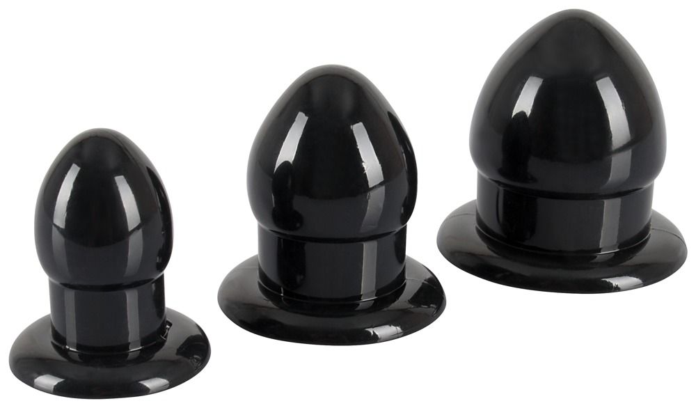 Trois plugs d'étirement anal noirs de différentes tailles sur fond blanc.
