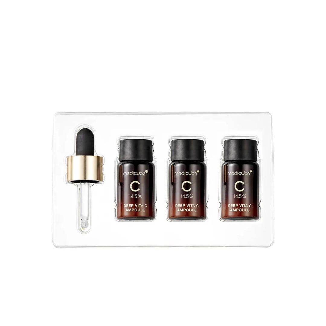 Emballage avec trois flacons de sérum et une pipette. Flacons avec bouchons noirs, bagues dorées. Récipient transparent.