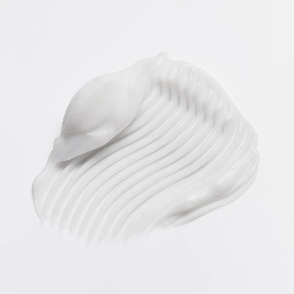 Gros plan de crème blanche. Crème en lignes ondulées sur fond clair.