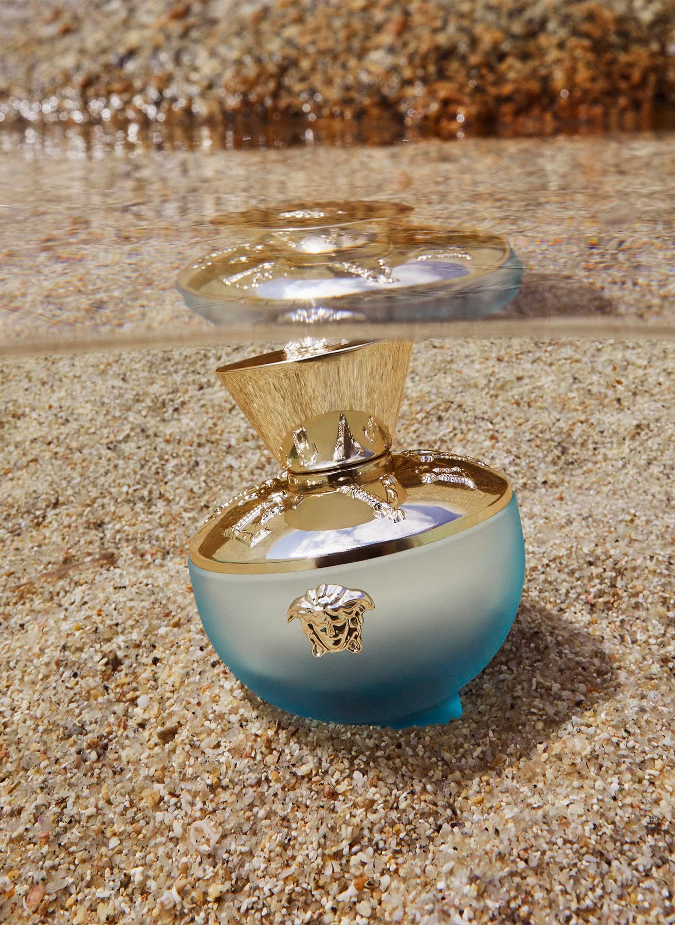 Flacon Versace Dylan Turquoise Eau de Toilette dans le sable et l'eau.