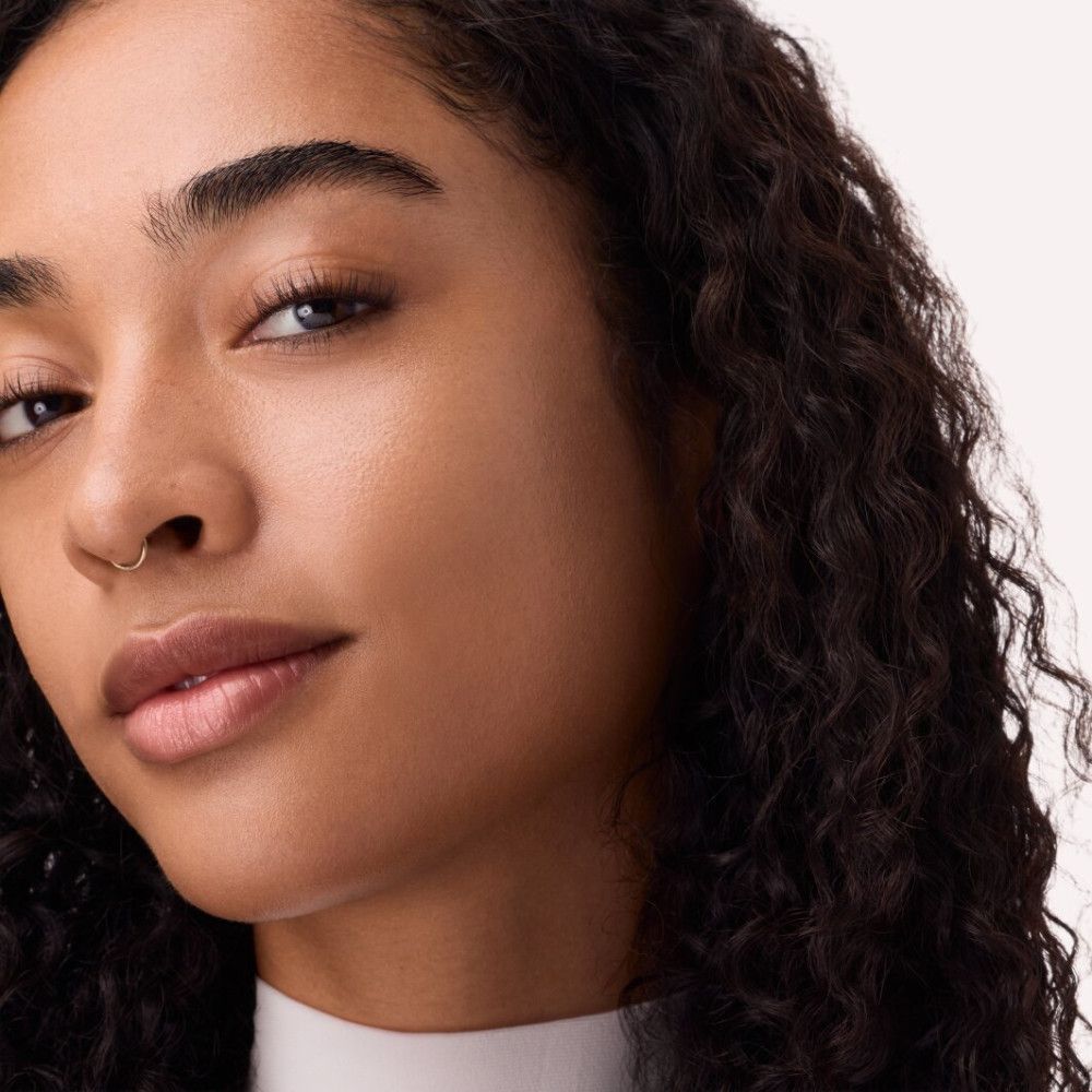 Gros plan d'un visage. Teint après application de Catrice Skin Like Tinted Moisturizer. Aspect naturel.