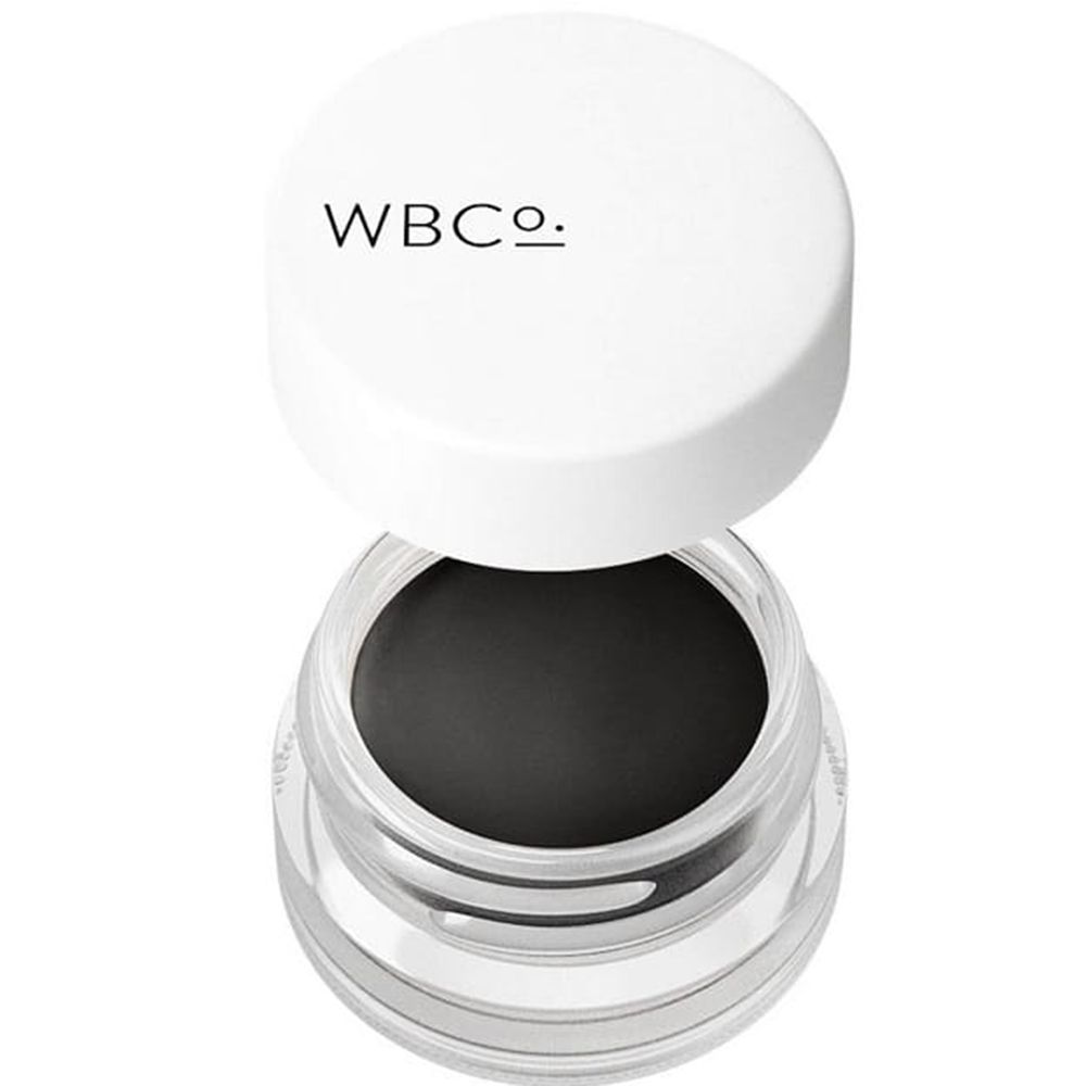 Pot en verre de pommade à sourcils noire. Couvercle blanc avec inscription "WBCo.".
