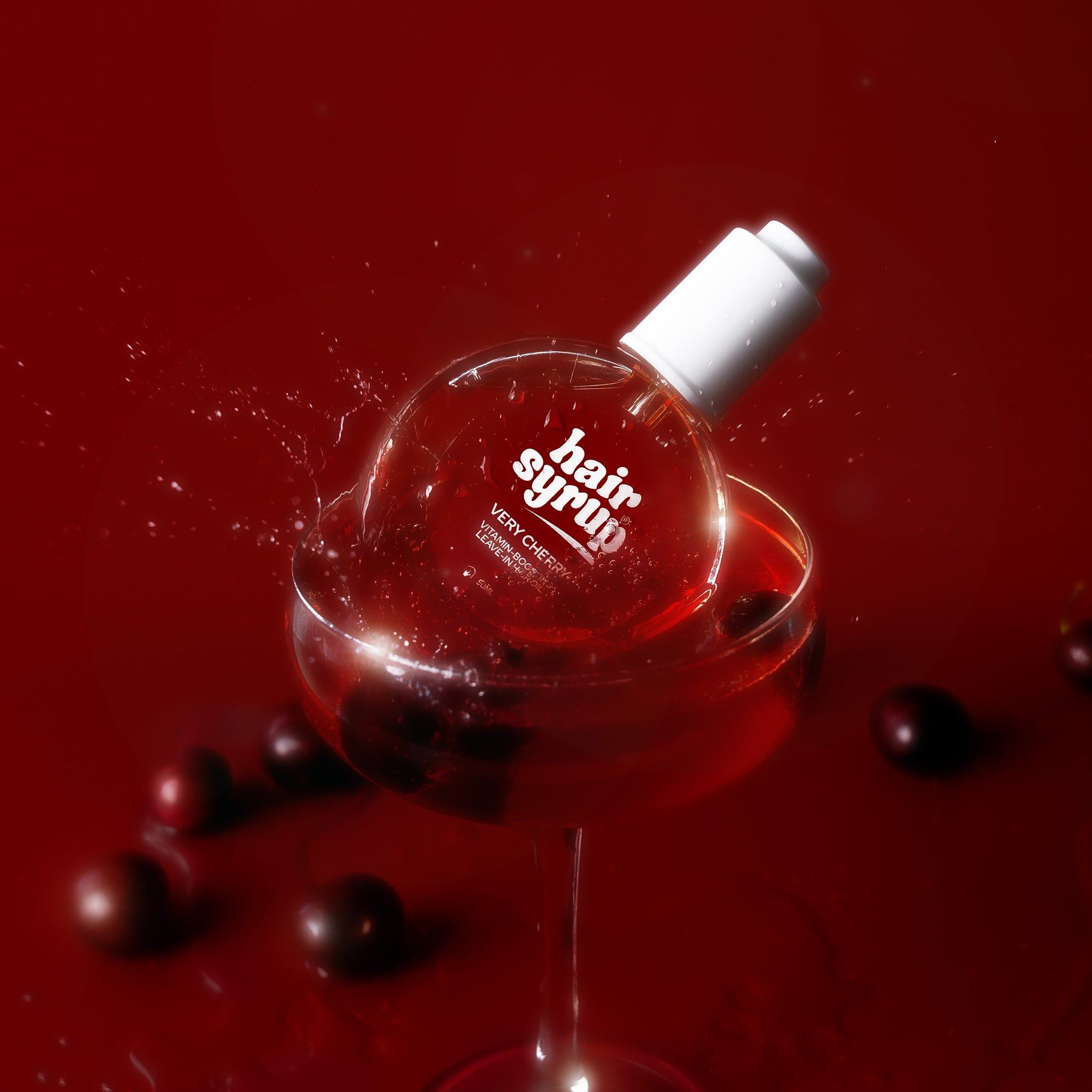 Ronde fles in een wijnglas met vloeistof. Kersen en spatten. Rood etiket.