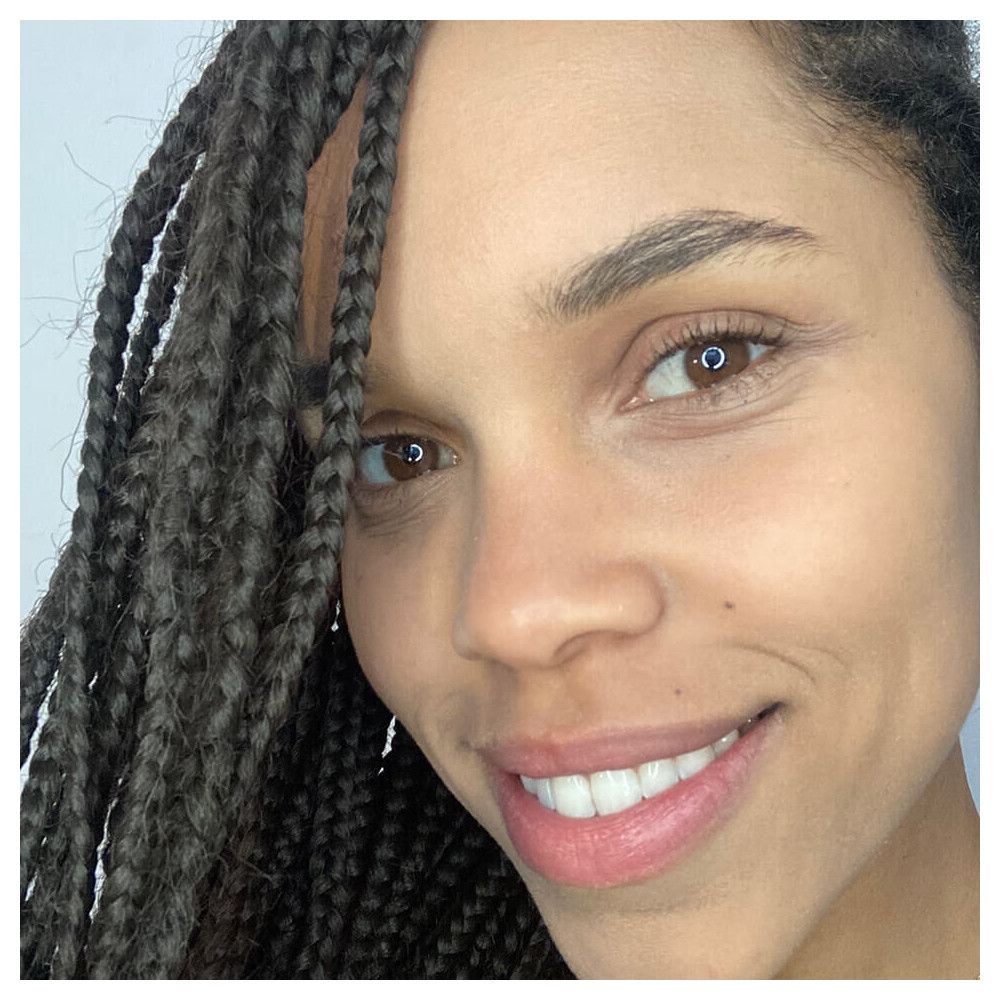 Gros plan d'un visage avec teint. Sourcils, yeux et lèvres visibles.