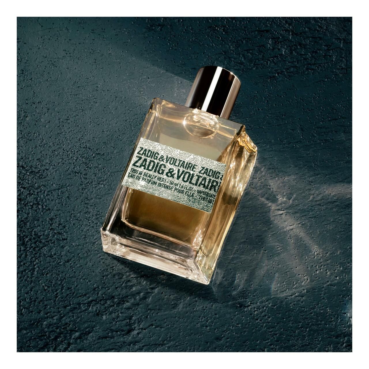 Flacon de parfum. Flacon rectangulaire avec bouchon argenté. Inscription et étiquette.