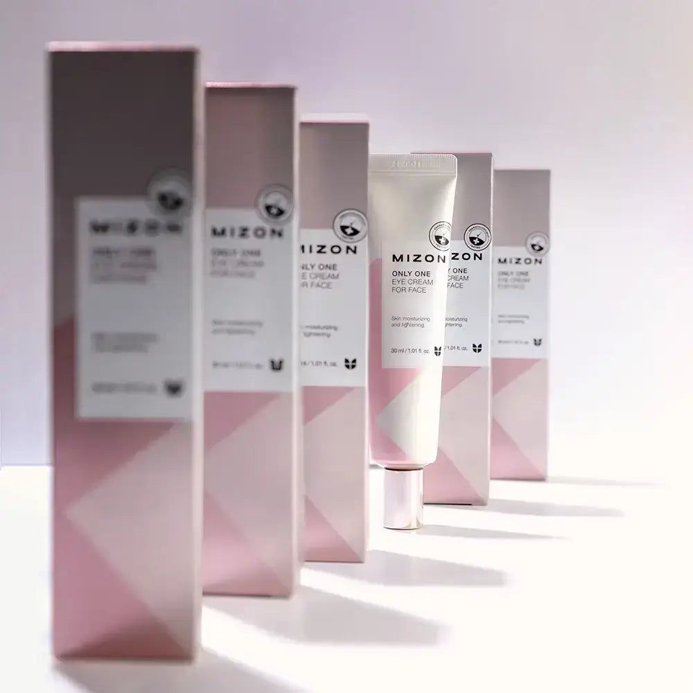 Rij MIZON oogcrèmeverpakkingen en een tube. Roze en witte verpakking met productnaam en logo.