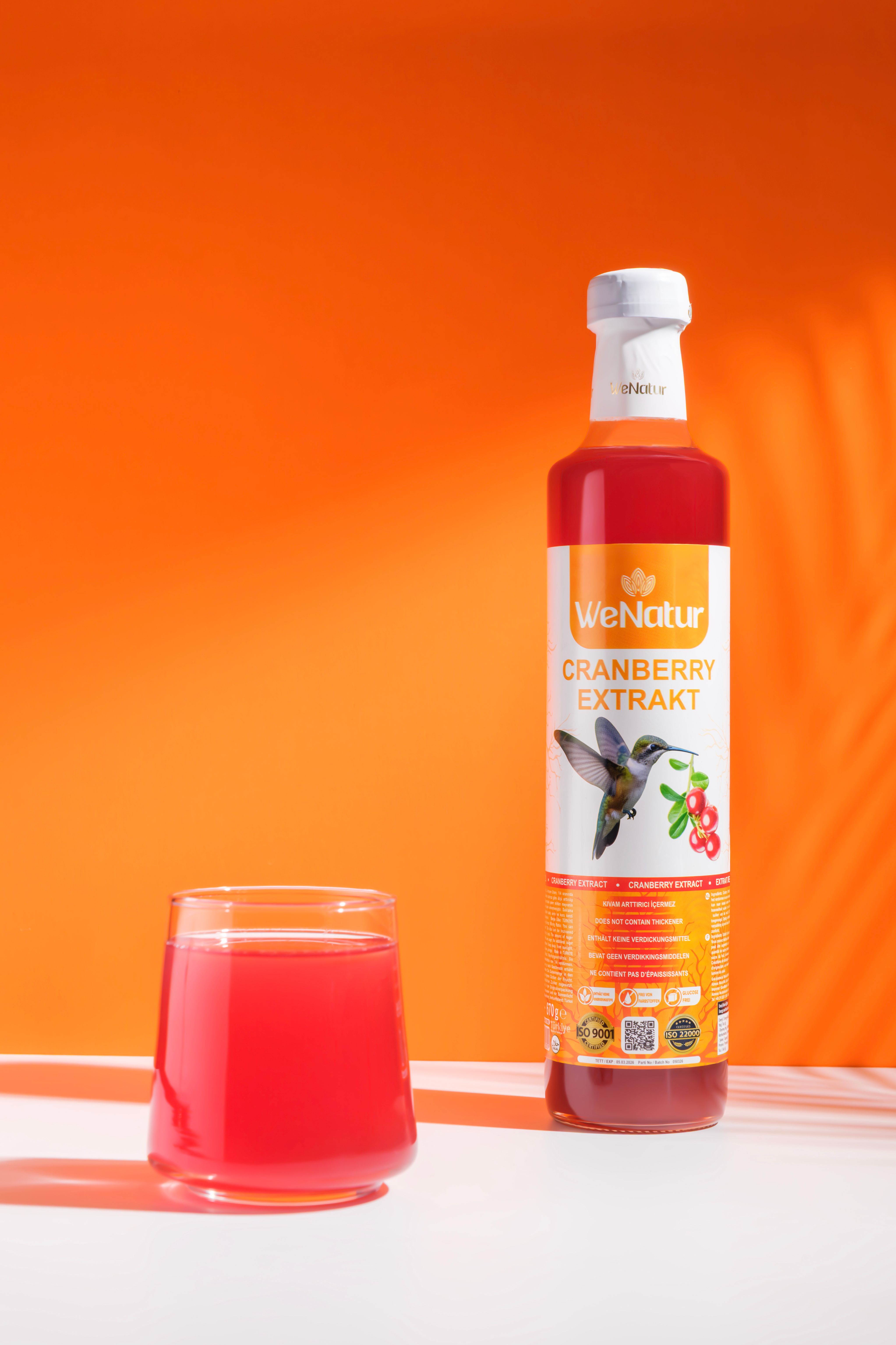 Bouteille d'extrait de canneberge et verre avec boisson.