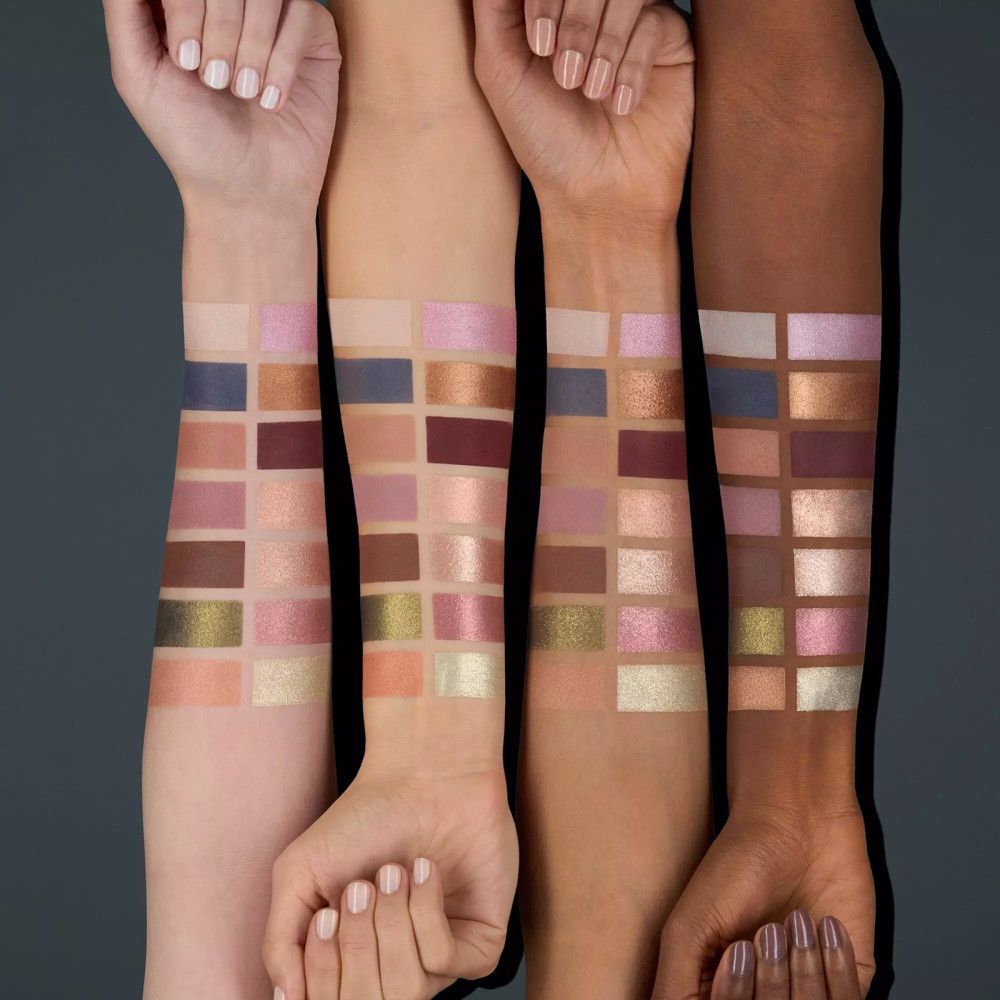 Bras de différentes carnations présentant des échantillons de fard à paupières. Diverses couleurs, dont rose, marron et or.