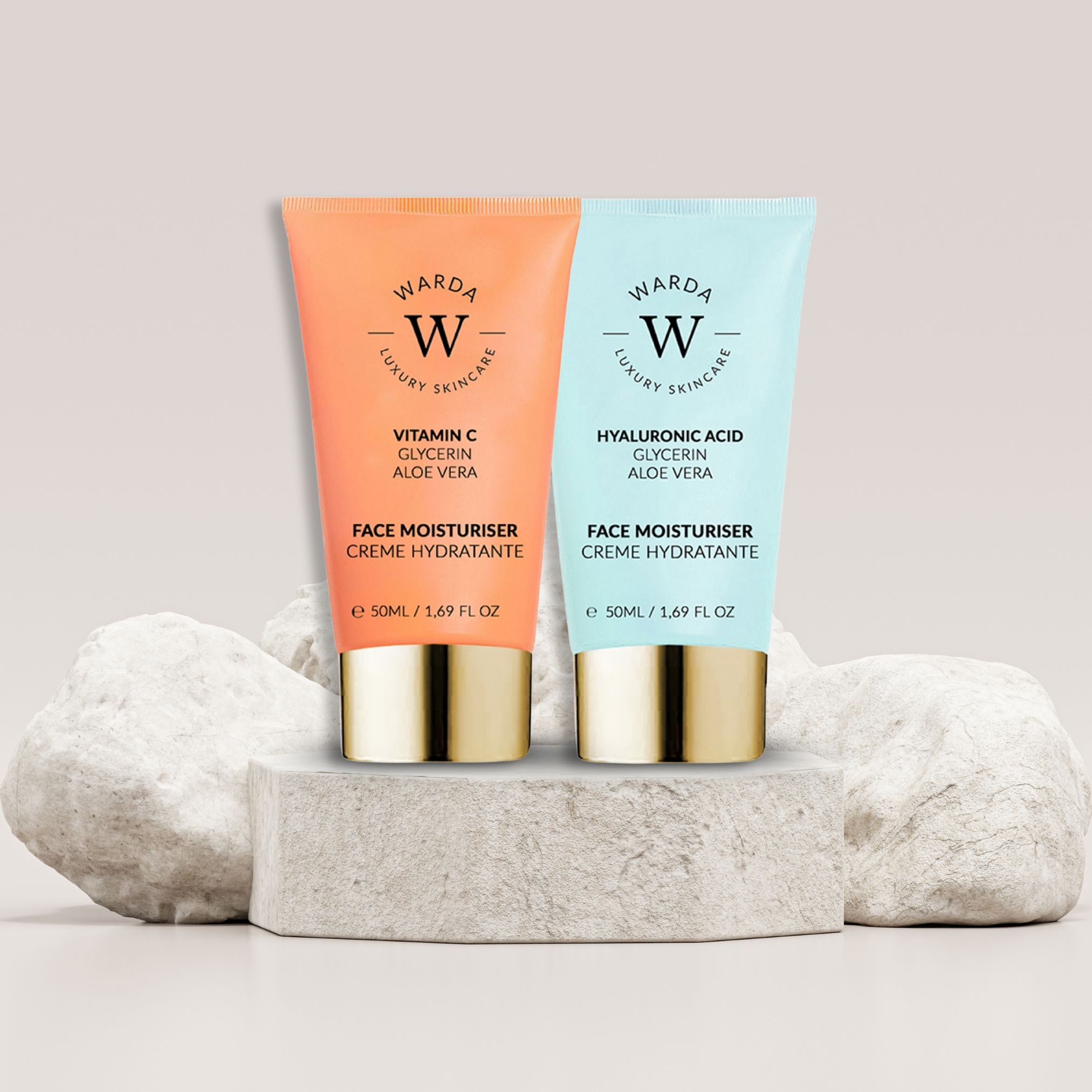 Deux tubes de crème de jour Warda sur un socle. Tube orange : Vitamine C. Tube bleu : Acide hyaluronique. Bouchons dorés.