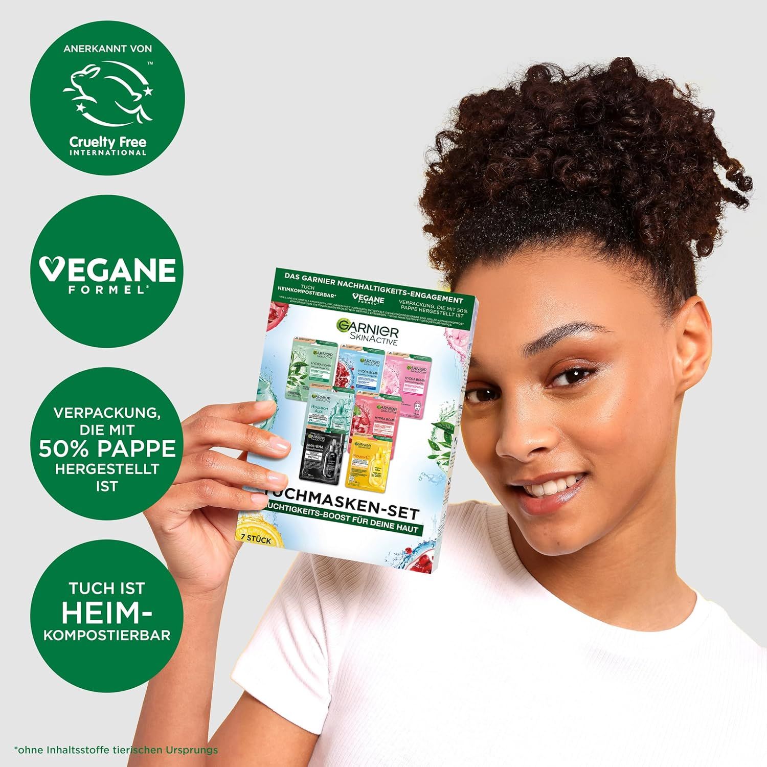 Femme tenant un coffret de masques en tissu Garnier. Emballage : Vegan, sans cruauté, 50% papier. Texte : Le tissu est compostable.