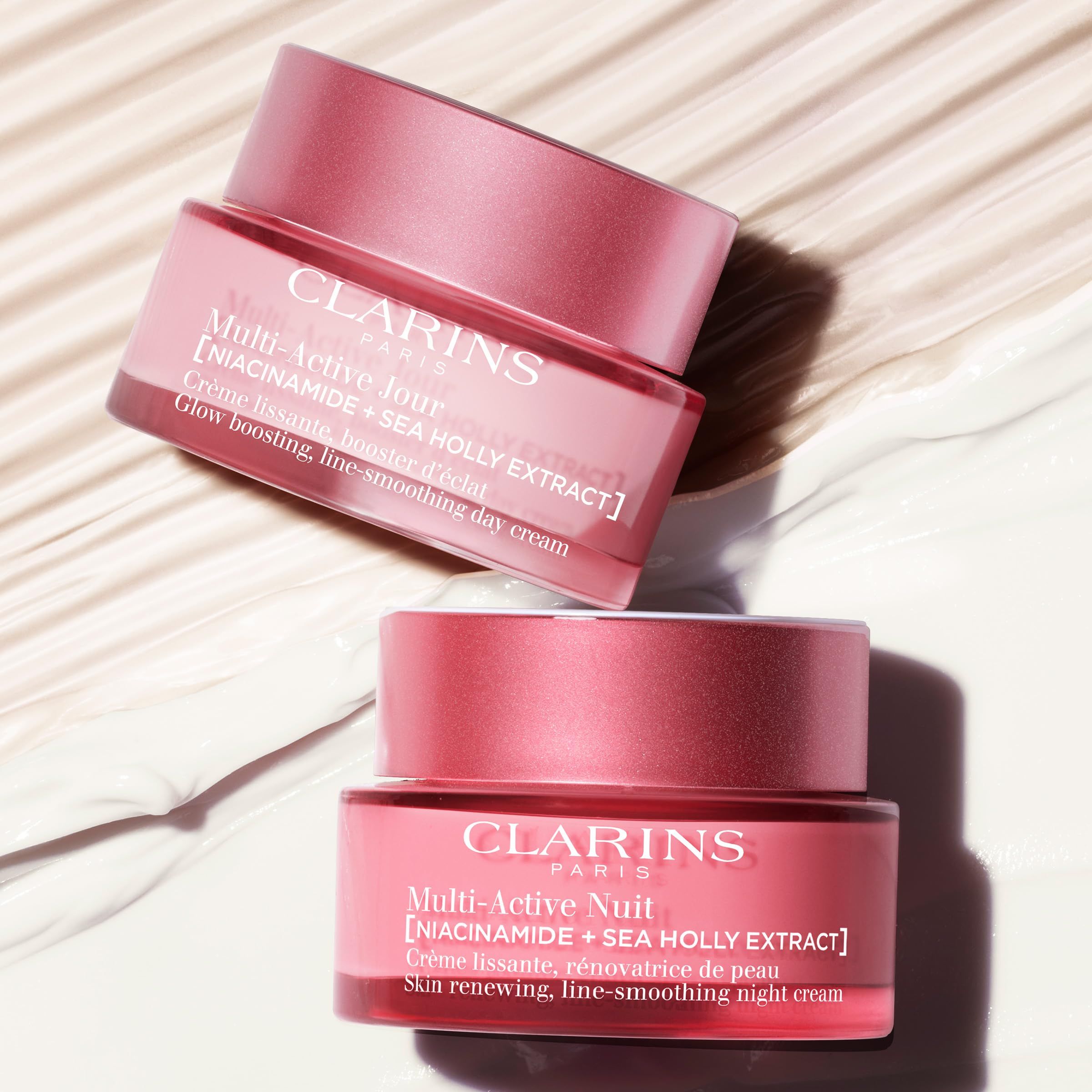 Twee roze crème potten met deksels. Opschrift: CLARINS PARIS, Multi-Active. Tekst: Skin renewing, line-smoothing day/night cream.