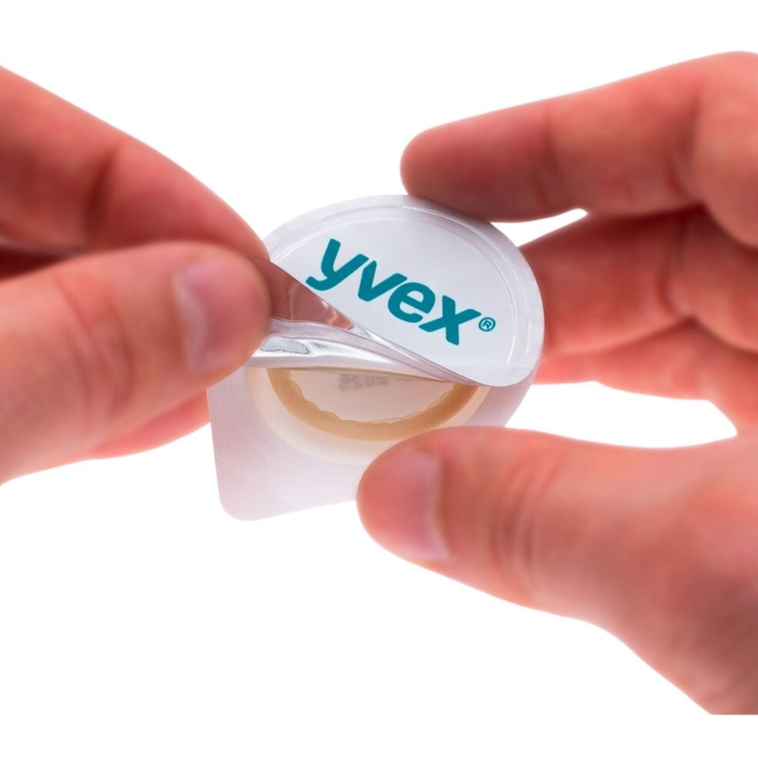 Handen openen een individuele verpakking. Opschrift "yvex". Product zichtbaar.