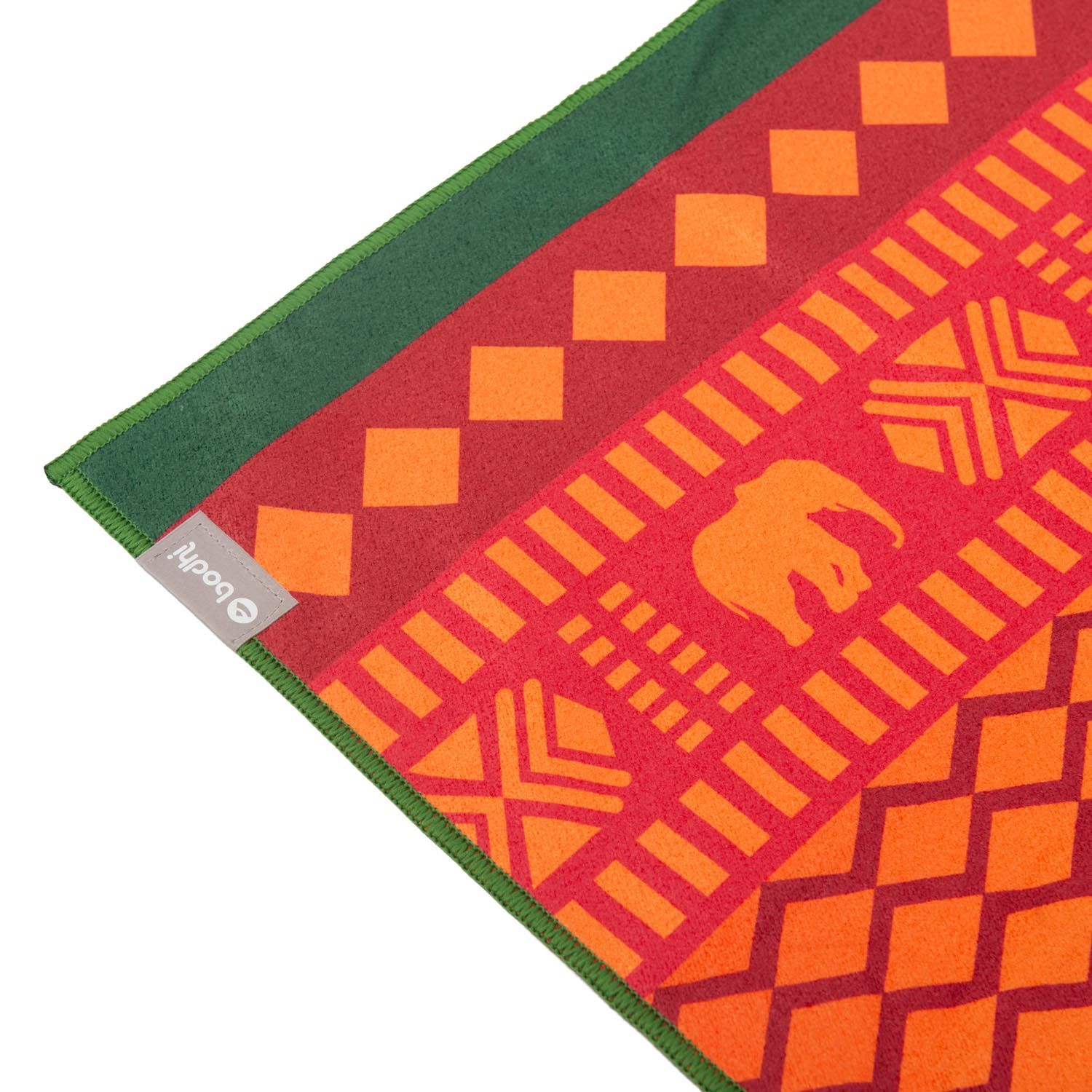 Serviette de yoga rot-gelb. Coin avec logo. Motifs éléphants, formes géométriques et bordures vertes.