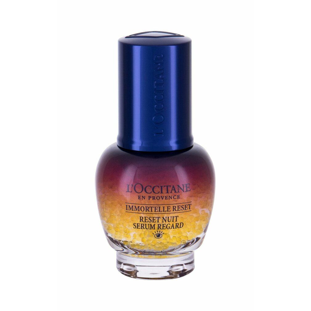 Flacon de sérum avec bouchon bleu. Inscriptions: L'Occitane, Immortelle Reset, Reset Nuit Serum Regard. Billes jaunes en bas.