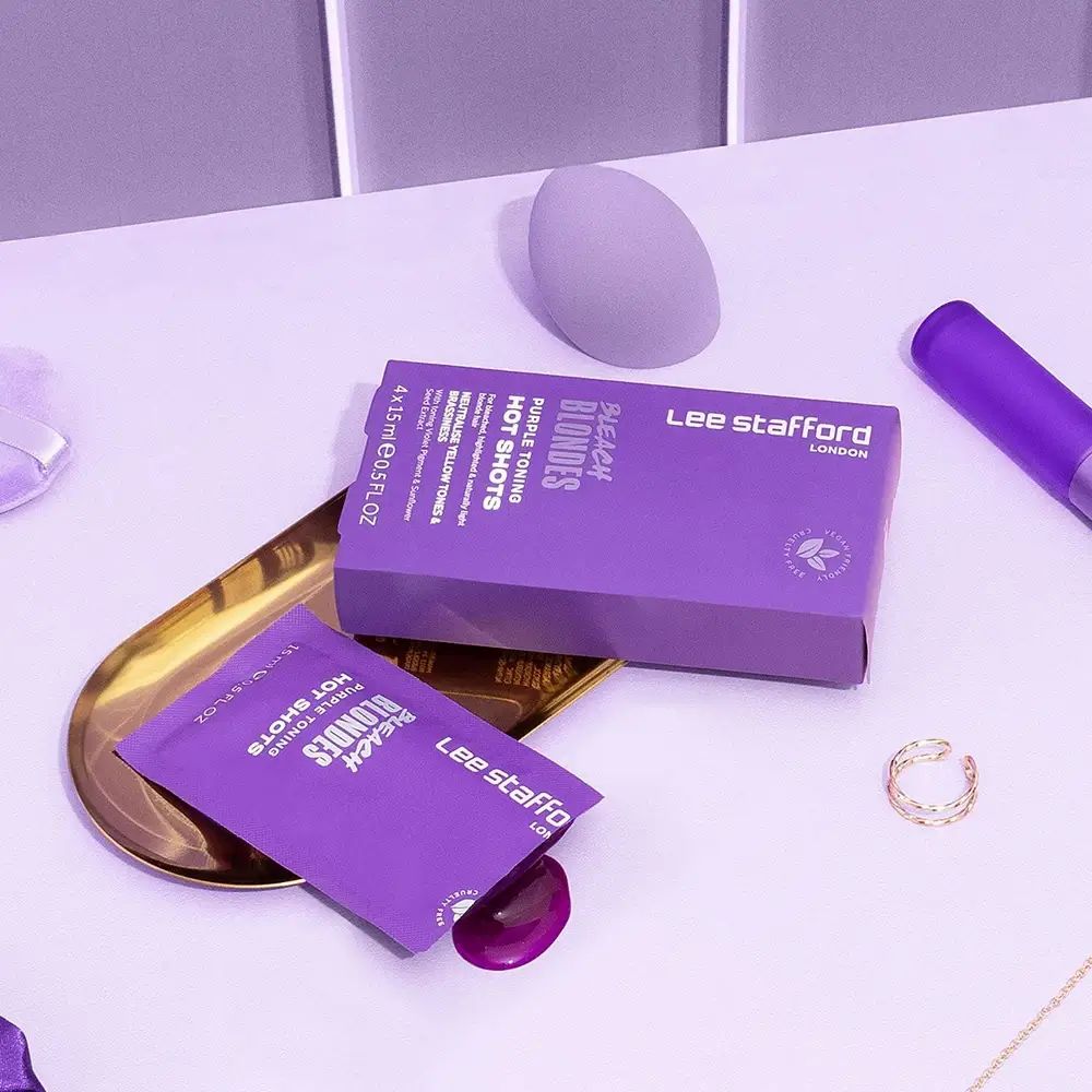 Productverpakking en zakje op dienblad. Paarse tint. Extra cosmetica-artikelen.