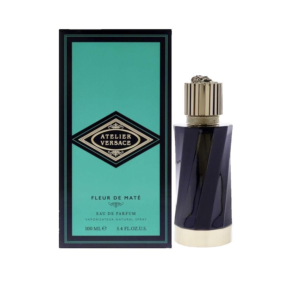 Flacon de parfum bleu foncé avec bouchon et base dorés. À côté, une boîte turquoise avec logo et texte.