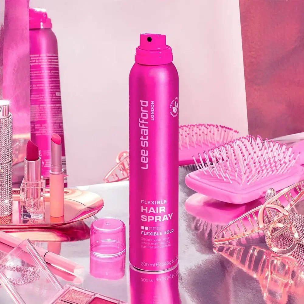Flacon Lee Stafford Flexible Hairspray avec brosses à cheveux roses et cosmétiques.